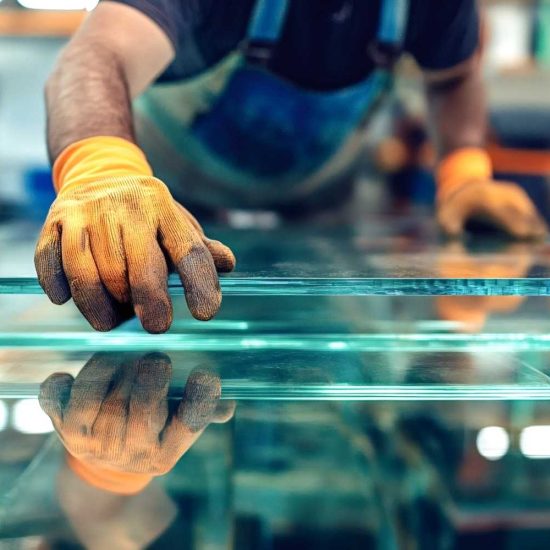 glazier-carefully-placing-glass-pane-factory (1)